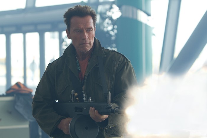 Arnold Schwarzenegger holding a machine gun
