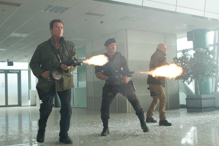 Arnold Schwarzenegger and Sylvester Stallone firing weapons