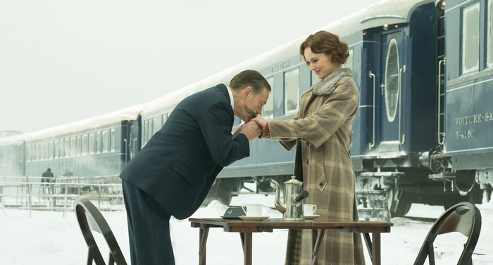Man kisses woman's hand by train