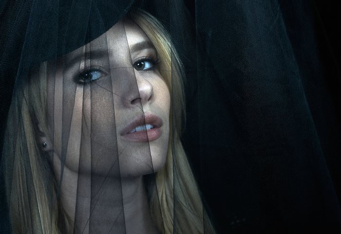 Emma Roberts behind a black veil