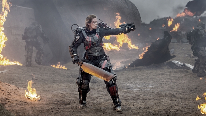 Emily Blunt in a futuristic suit with a sword and gun