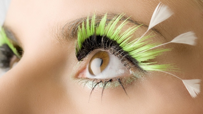 Close-up of eye with neon green and white feather eyelashes