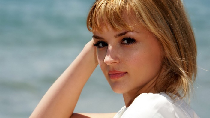 Woman with blonde hair by the ocean
