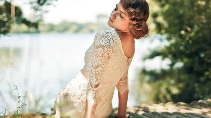 Woman in lace dress by a lake
