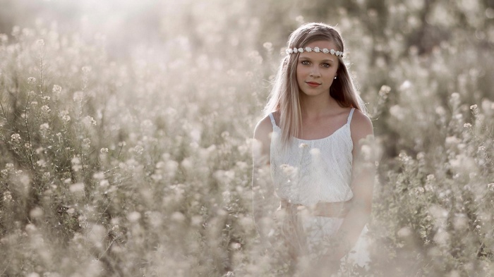 Girl with flower crown in a field of flowers