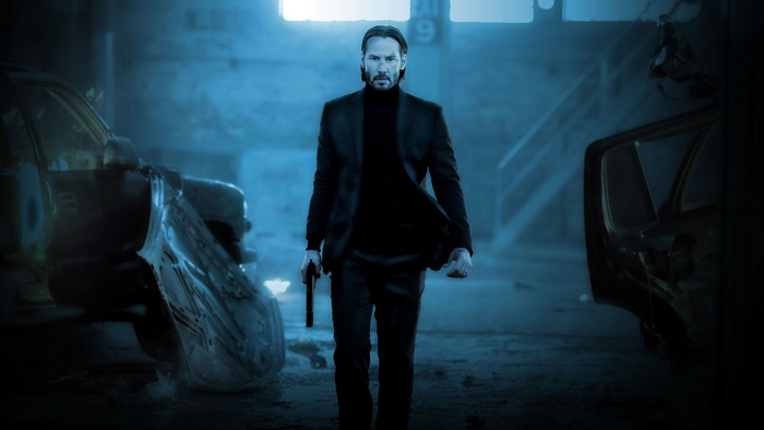Keanu Reeves as John Wick holding a gun