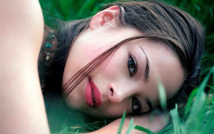 Kristin Kreuk lying in grass