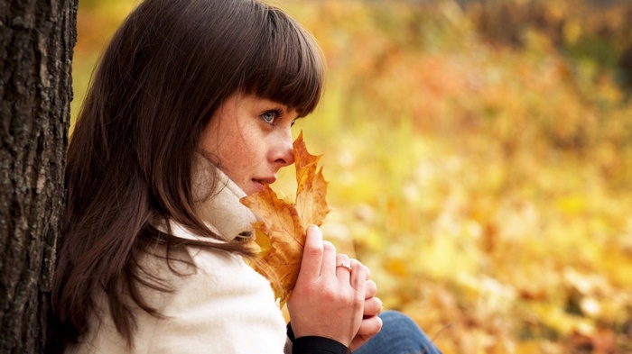 Woman holding a leaf in autumn