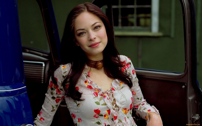 Kristin Kreuk in a floral shirt near a car