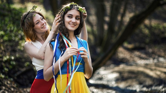 Two women with flower crowns in a forest