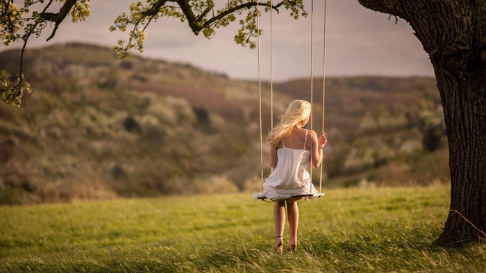 Woman on a swing under a tree