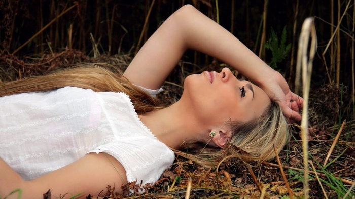 Woman lying in dry grass