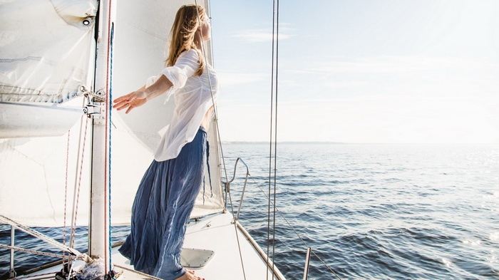 Woman on a sailboat enjoying the ocean view