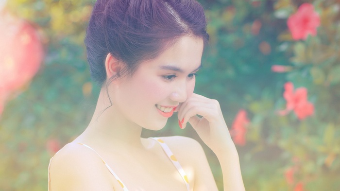 Young woman with flowers in the background