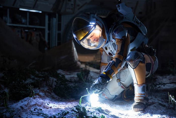 Astronaut examining a plant on Mars