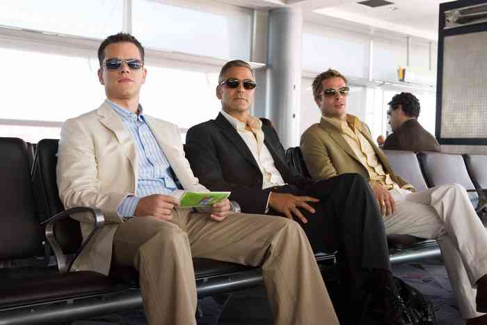 Three men in suits at an airport waiting area