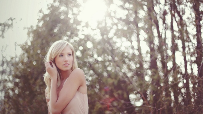 Woman with blonde hair in a tan top