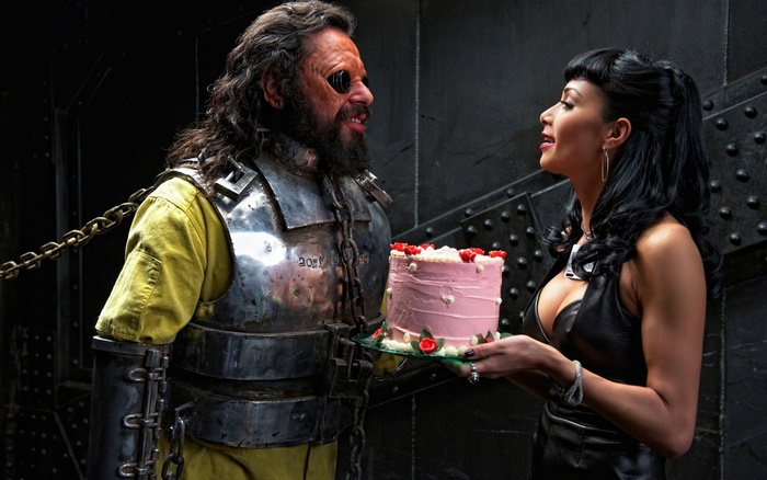 Nicole Scherzinger and a chained man with a cake