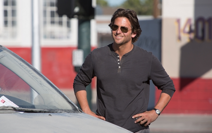 Bradley Cooper leaning on a car