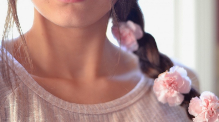 Close-up of a person with flowers in their braid