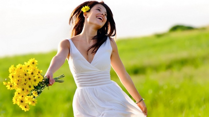 Woman in white dress holding yellow flowers