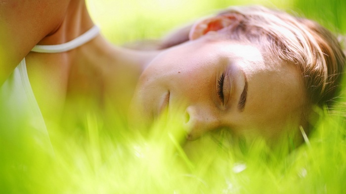 Woman sleeping in green grass