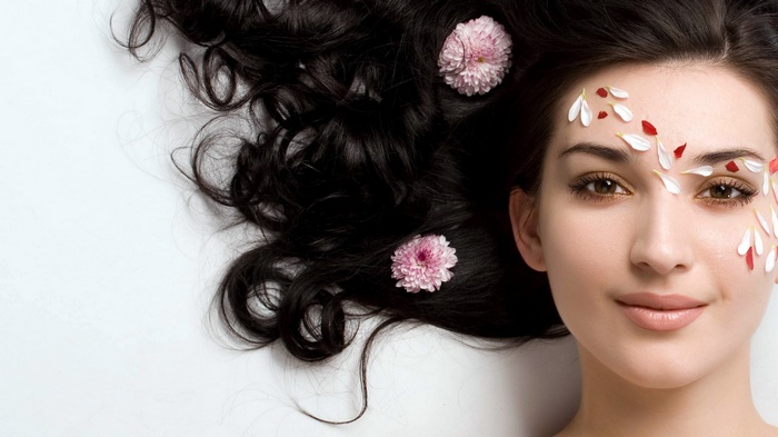 Woman with flowers and petals on her face and hair