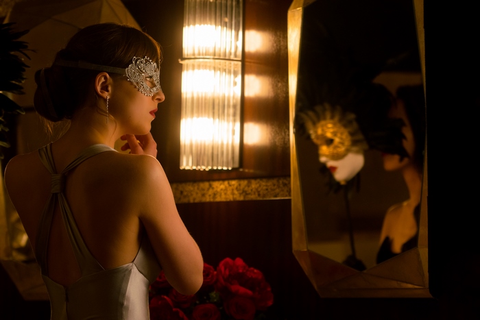 Dakota Johnson in Silver Dress Wearing Intricate Mask
