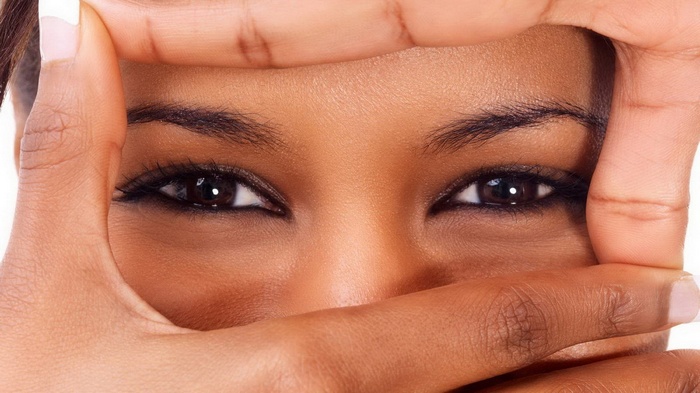 Close-up of a woman's eyes framed by hands
