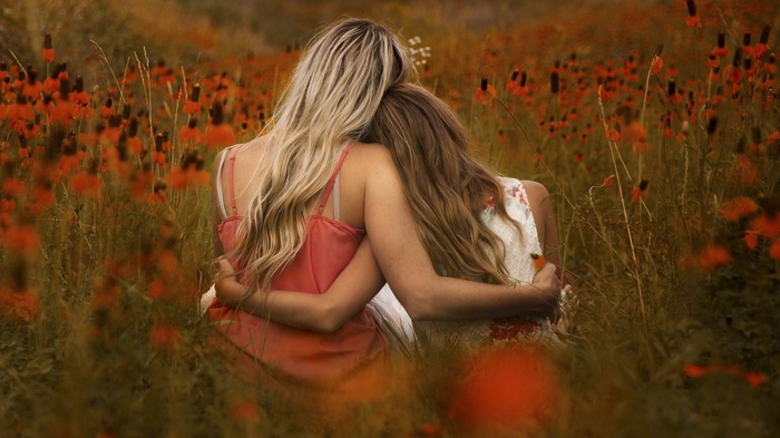 Two women hugging in a field of flowers