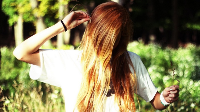 Woman with long blonde hair in a white t-shirt
