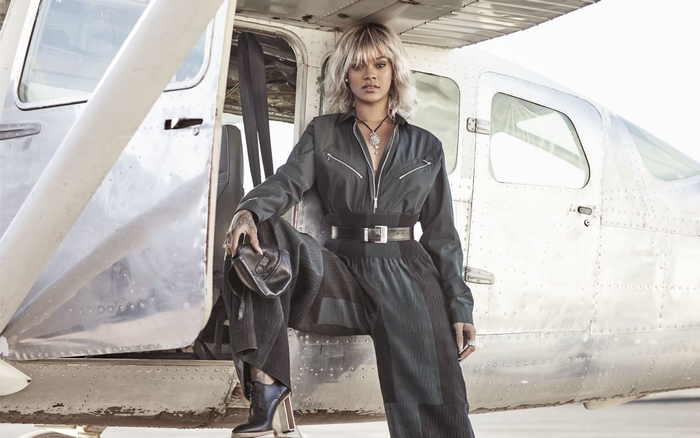 Rihanna posing by a small airplane