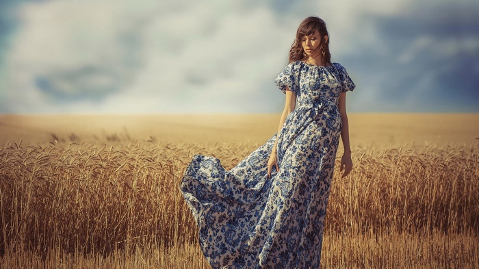Woman in a floral dress in a wheat field