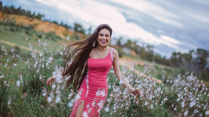 Woman in pink dress in a field of flowers