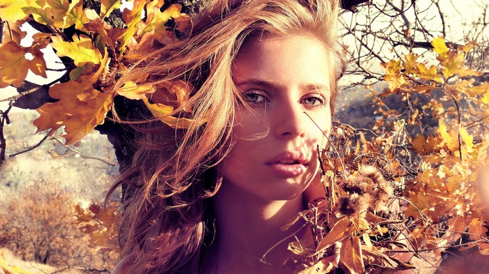 Woman with blonde hair among autumn leaves