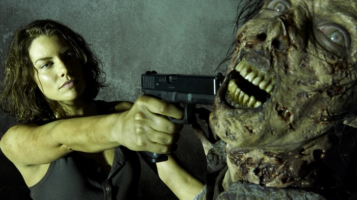 Lauren Cohan aiming a gun at a zombie