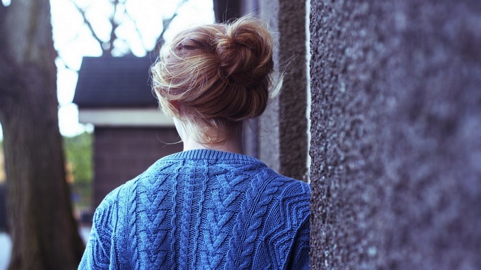 Woman with hair bun wearing blue sweater