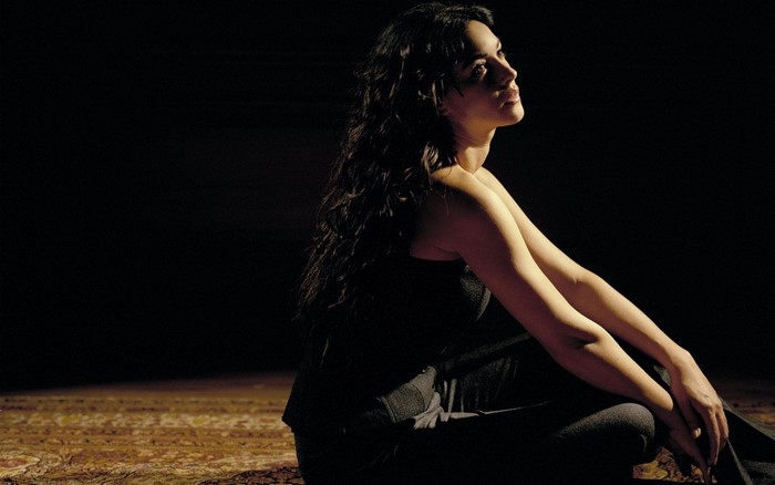 Monica Bellucci sitting on a carpet