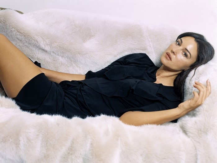 Monica Bellucci lying on a furry couch