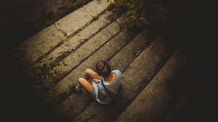 Woman sitting on concrete stairs