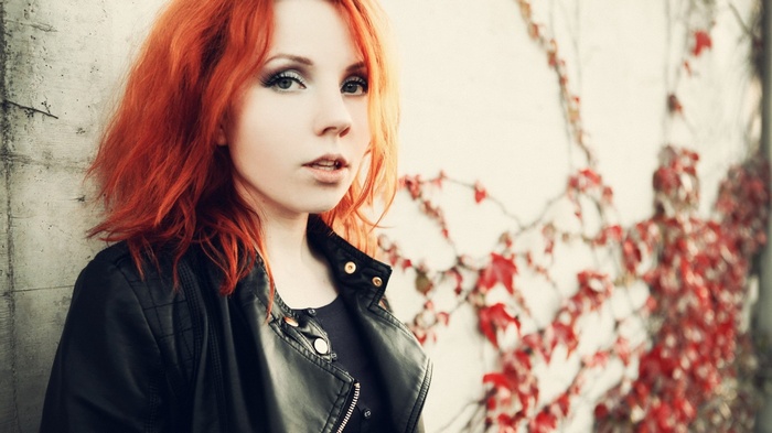 Woman with red hair wearing a black jacket