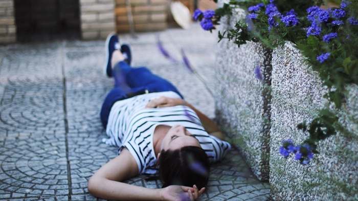 Woman lying on the ground near flowers
