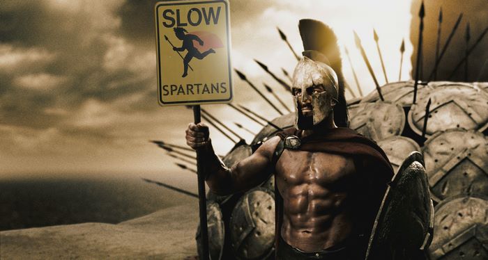 Spartan warrior holding a 'Slow Spartans' sign