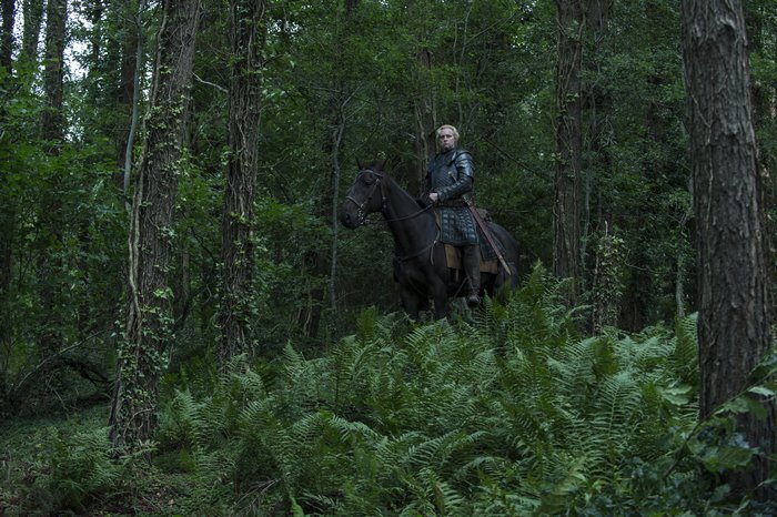 Gwendoline Christie on horseback in a forest