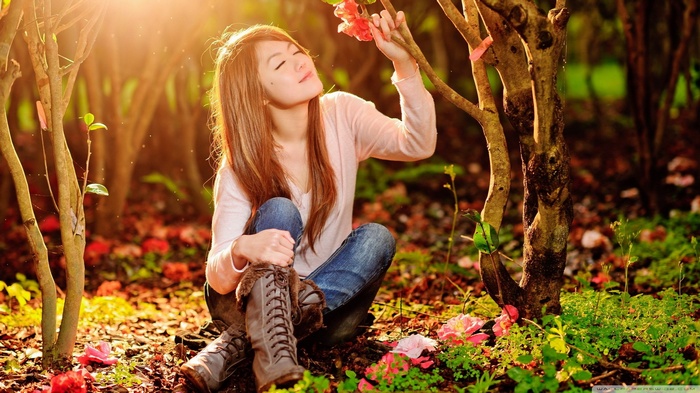 Young woman smelling a flower in a garden