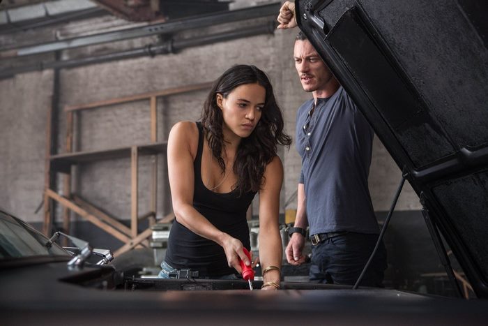 Michelle Rodriguez and Luke Evans working on a car