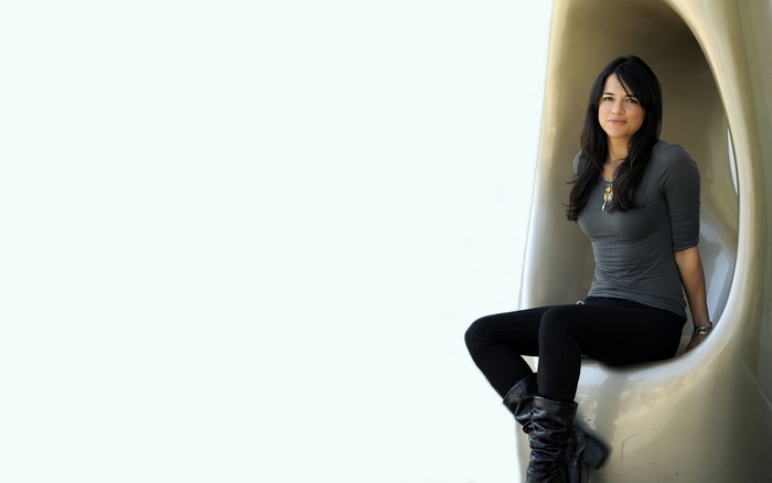 Michelle Rodriguez sitting in a modern sculpture