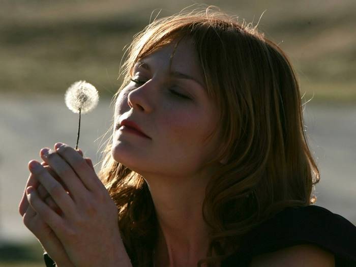 Kirsten Dunst holding a dandelion
