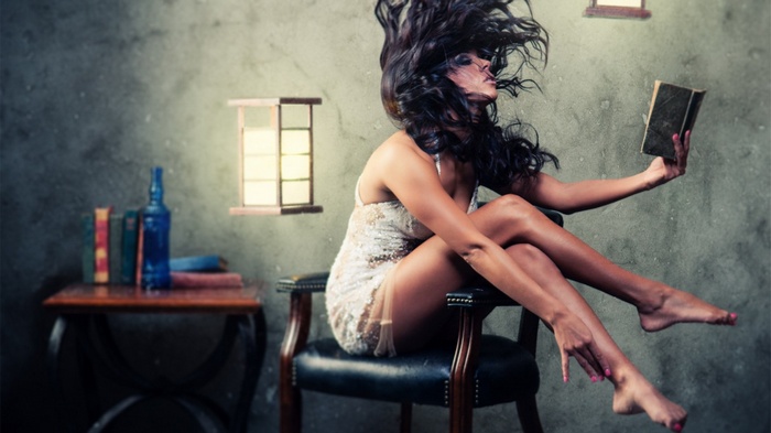 Woman reading a book while sitting in a chair