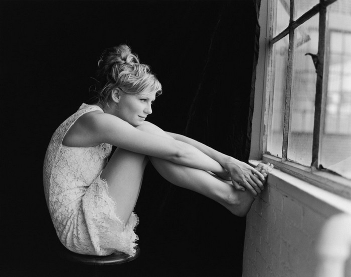 Kirsten Dunst sitting by a window